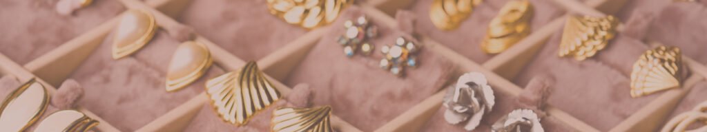 Vintage old-fashioned earrings at flea market stall or car boot sale. Retro style jewelry. Vintage goods for sale. Garage sale concept. Selective focus